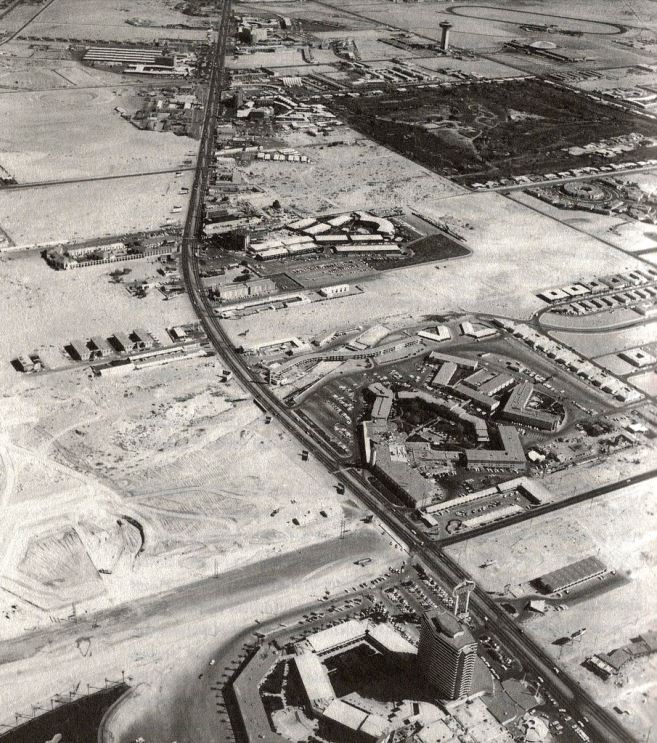 Sands hotel tower can be seen under construction in the upper middle part of the photo. Lower left, the beginnings of Caesars Palace. On the far lower right, Three Coin Motel and Galaxy Motel._1965