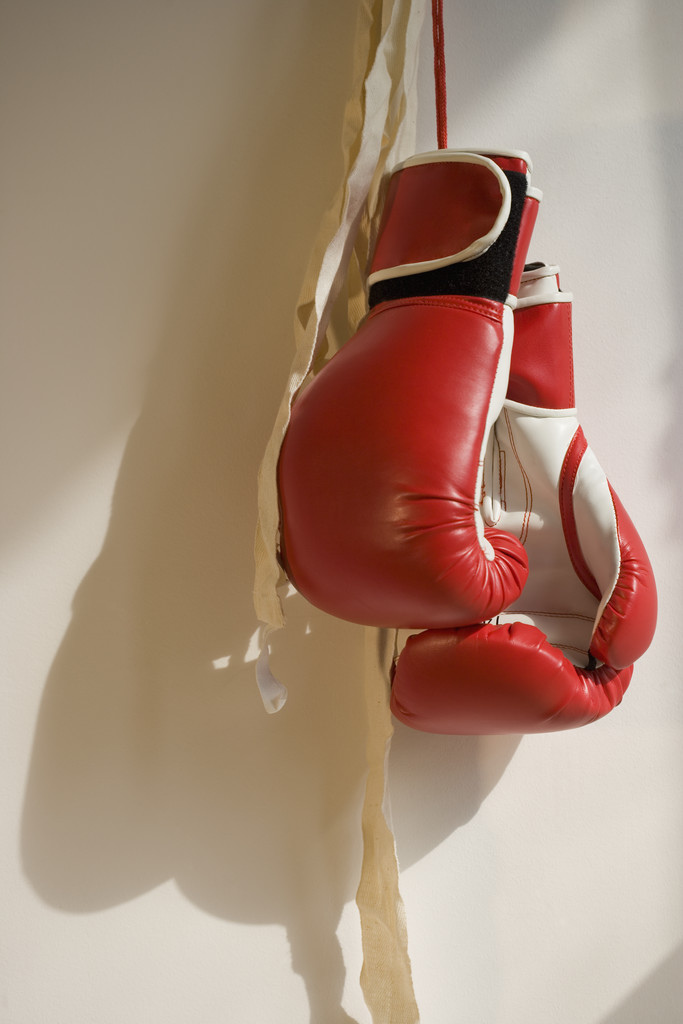 Red boxing gloves hanging on wall