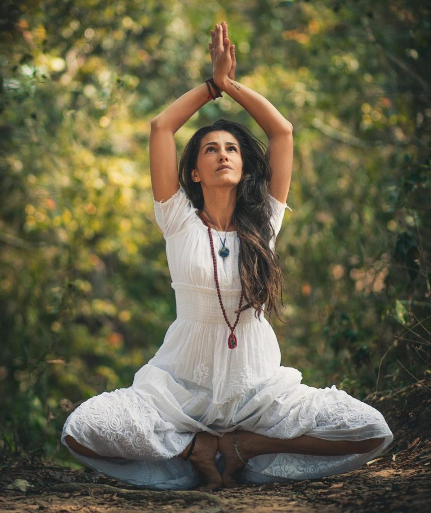woman squatting on ground while raising both hands