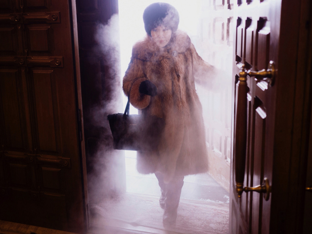 A local woman enters preobrazhensky cathedral in a swirl of freezing mist.