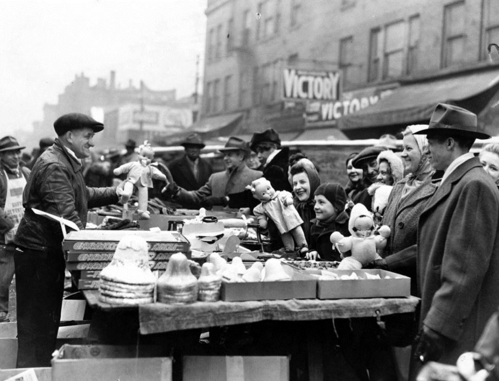 A Maxwell Street vendor tries to entice late Christmas shoppers with ornaments and dolls on Dec. 24, 1944.