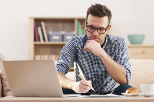 ethical essay writing, man focusing on laptop