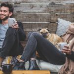 happy young student couple with a pug dog