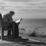 old man reading outside