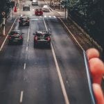 cars running on the road below smartphone