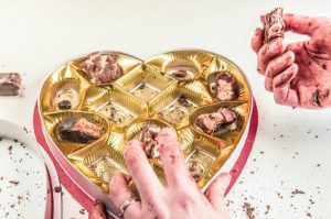 picking chocolates from can