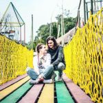 young couple on rope wooden bridge