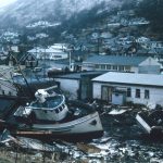 white and brown boat on black sand