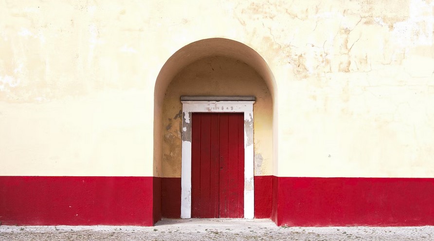 Beautiful red gate on yellow wall background