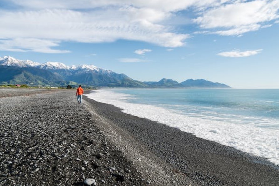 Young man walking calmly on beach side