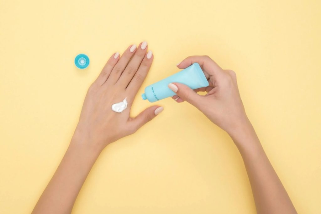 girl apply sunscreen on her hand