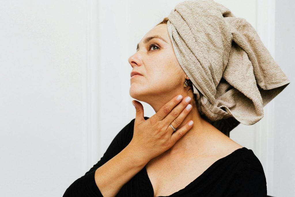 women apply neck cream after bath