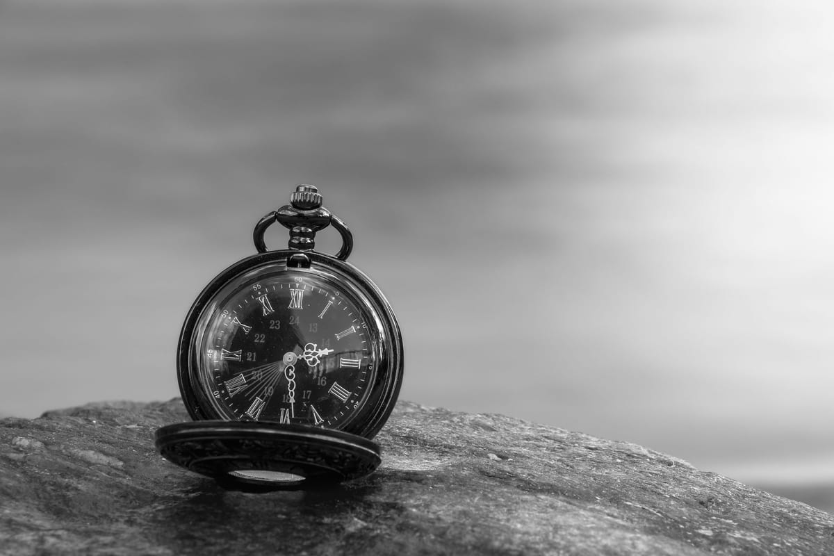 Vintage pocket watch resting open on a textured stone, symbolizing the time needed for compounding wealth.